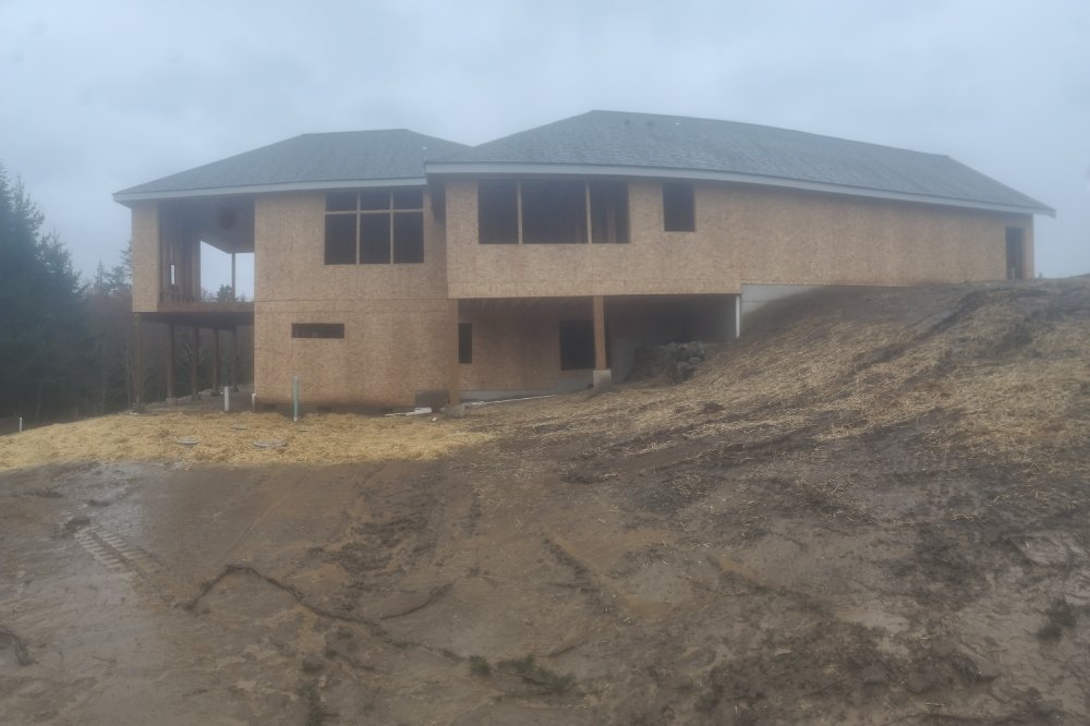 Sheathed and roofed new home on a hillside lot